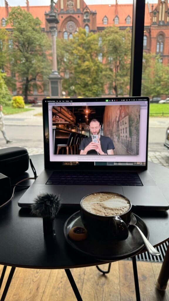 Edward Sturm taking a photo of his laptop in front of a delicious cappuccino. Recording equipment to the side.