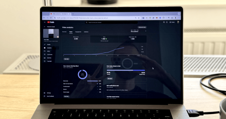 My MacBook Pro with Viral Youtube metrics and me giving the peace sign in the reflection.