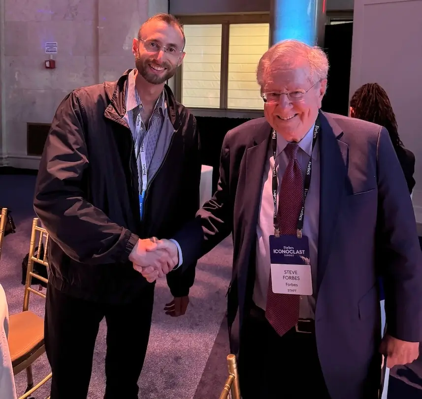 Edward Sturm shaking hands with Forbes' Chairman and Editor-in-Chief, Steve Forbes