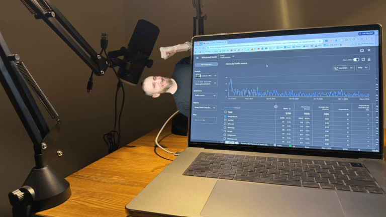 Laptop displaying YouTube Analytics traffic from Google Search beside a podcast microphone setup, representing the video SEO content discoverability system I use to generate long-term organic search visibility through podcasts and videos.