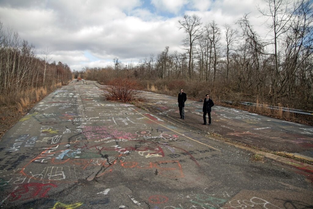 Edward Sturm and Michael Sorace, both in suits, on the famous PA Route 61 Highway in Centralia, Pennsylvania in 2013.