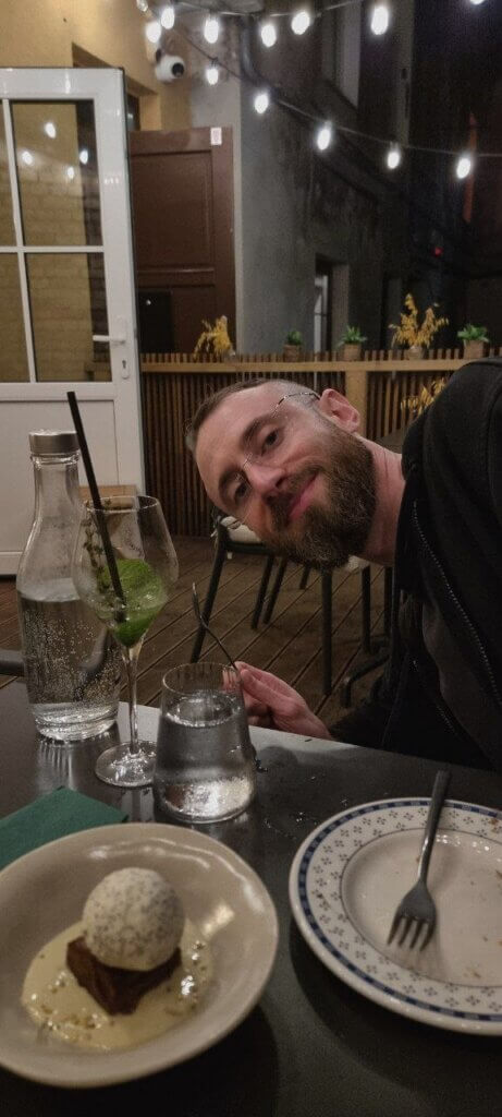 Edward Sturm, smiling, holding a spoon, at a restaurant with delicious poppy seed ice cream - Europe, 2026.