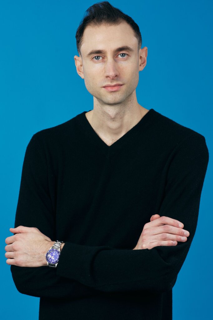 Edward Sturm business headshot against a blue background. Photo taken in 2021.