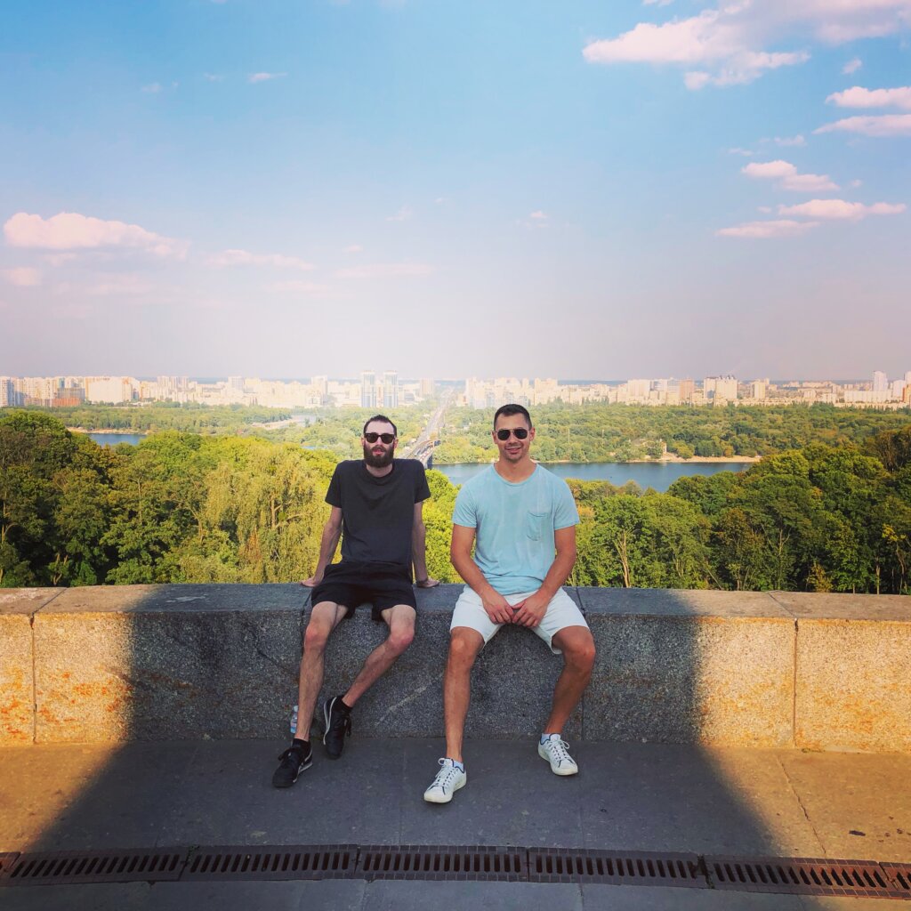 Edward Sturm and Daniel Zaffetti sitting at a lookout over the Dnieper River in Kyiv, Ukraine in 2019.