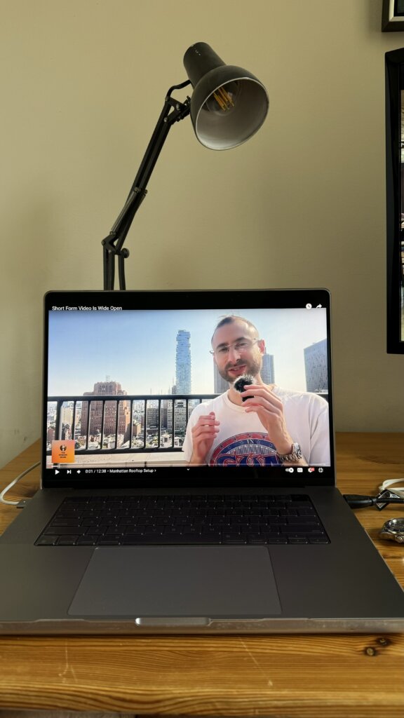 Edward Sturm recording his podcast, The Edward Show, on a Manhattan rooftop in 2024. Photo taken from the vantage point of a laptop on a desk.