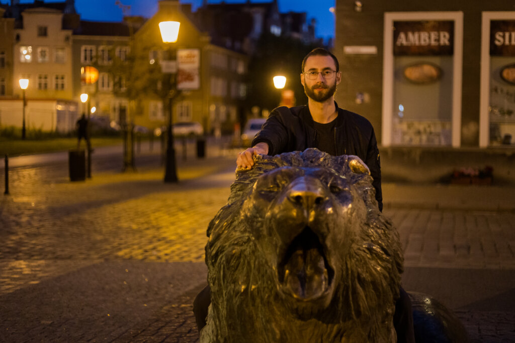 Edward Sturm with bronze lion in the Old Town of Gdańsk, Poland in 2019.