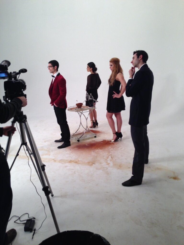 Edward Sturm in a suit on the set of his video, "Millennial High Art." In the background are Eva Maria, Samantha Fox, and Michael Sorace. Photo taken in New Jersey, 2014.