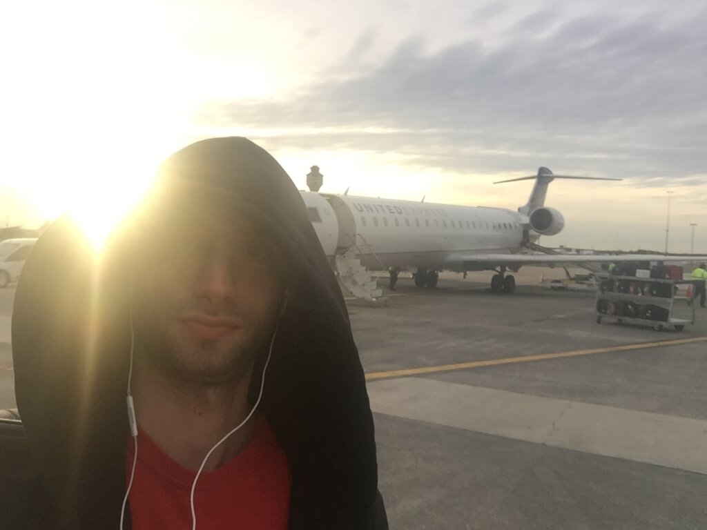 Edward Sturm on the tarmac at Los Angeles International Airport. Behind him is a United Jet and the sunset. Taken in 2015.