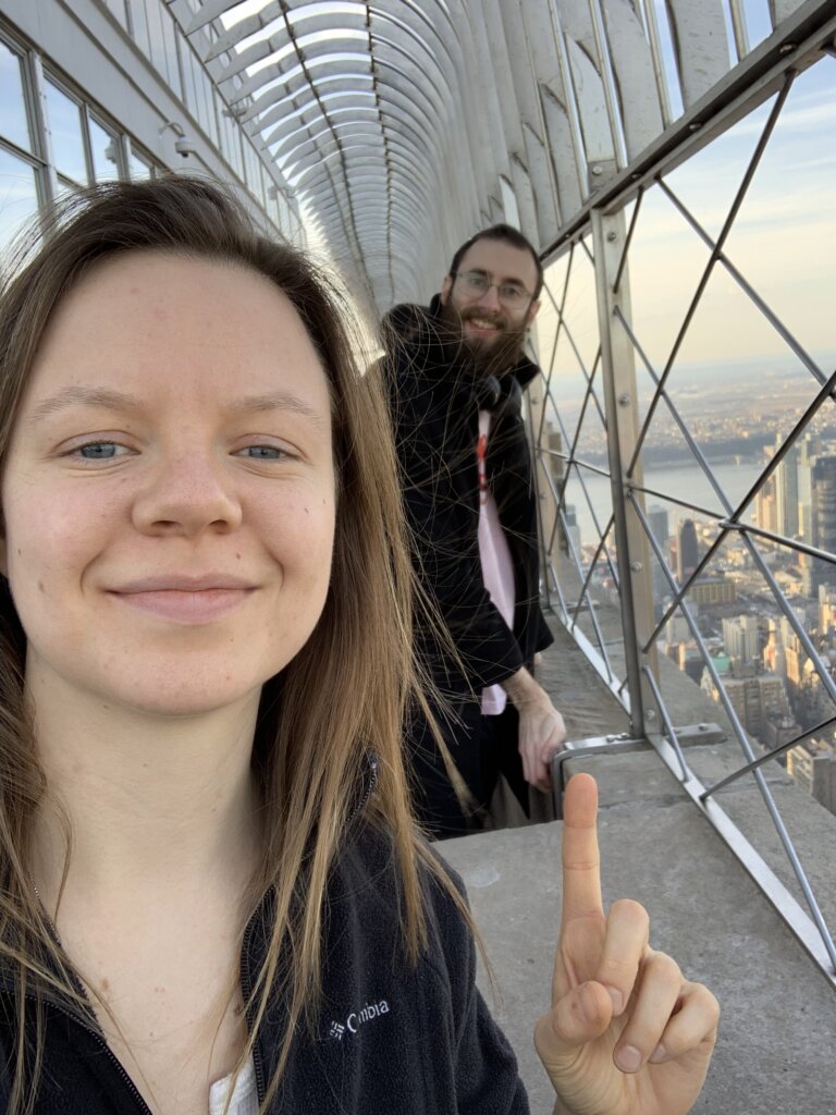 Lucie McCormick pointing to Edward Sturm on the observation deck of the Empire State Building in NYC in 2018.