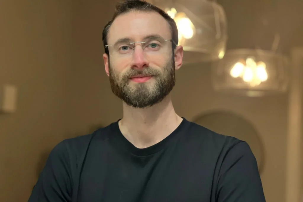 Edward Sturm in a black shirt, standing in a luxury apartment in Warsaw during a photo shoot in 2023.