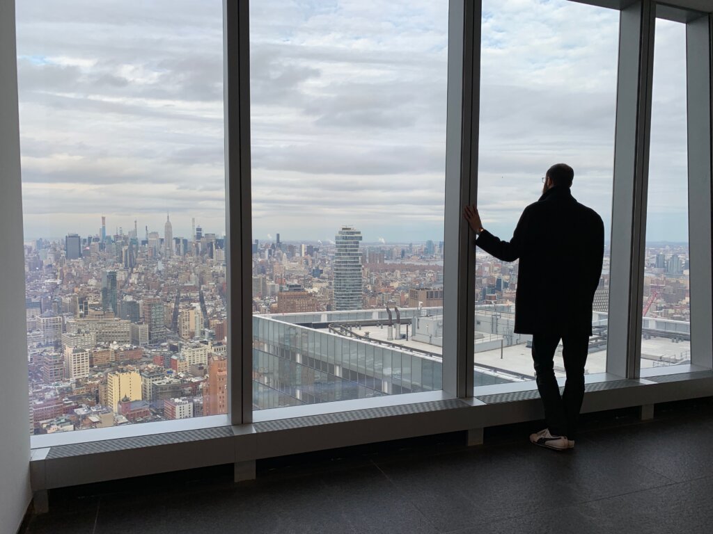 Edward Sturm standing in The World Trade Center, looking out over Manhattan in 2019.