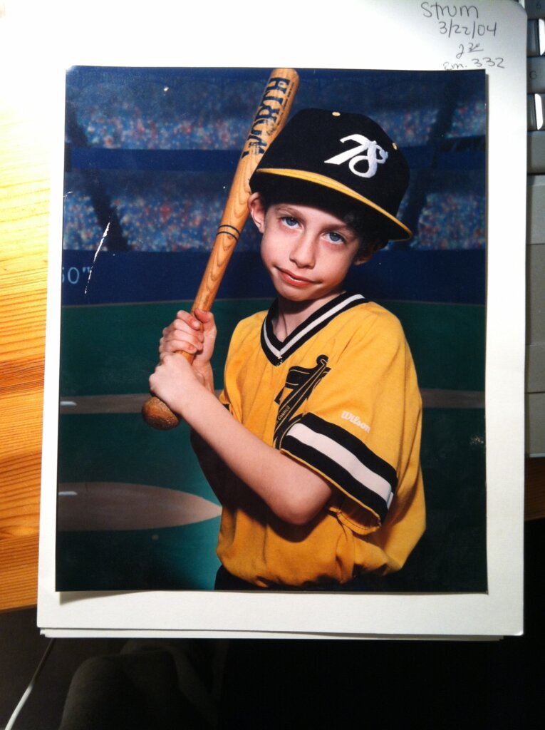 Edward Sturm, young, as a boy, holding a baseball bat. Photo taken in NYC in the 1990s.